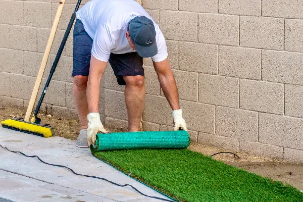 Man Installing Artificial Turf on a Patio